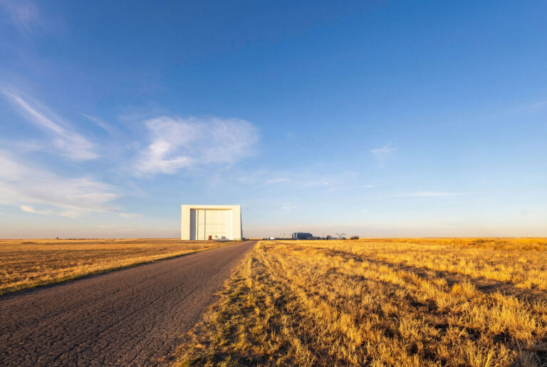 Road leading to large HAPS Hanger building on prairie