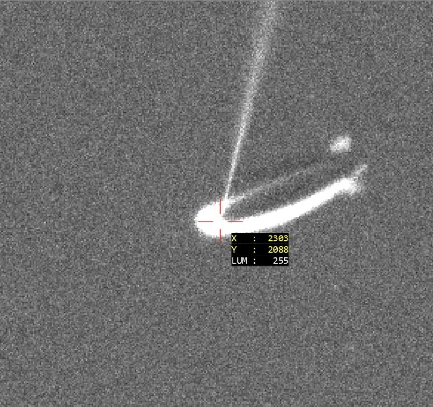 Grayscale radar-like image showing bright streaks and coordinate marker